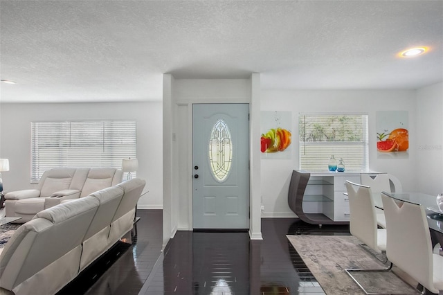 entrance foyer with baseboards, dark wood finished floors, and a textured ceiling