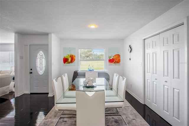 dining space with baseboards and dark wood-type flooring