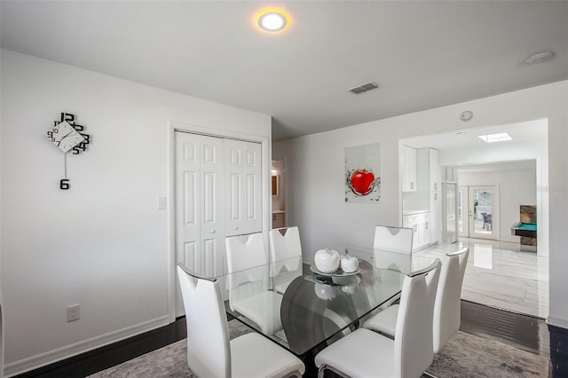 dining room with dark wood-style floors, visible vents, and baseboards