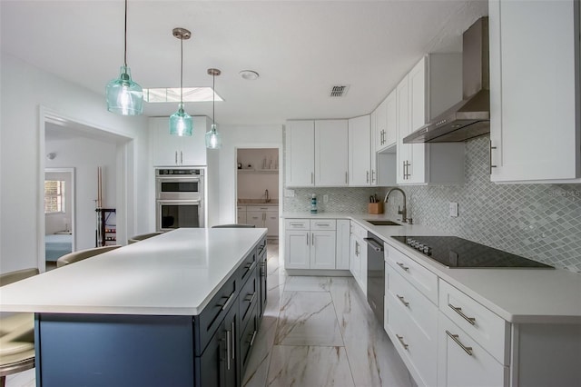 kitchen featuring a sink, marble finish floor, appliances with stainless steel finishes, decorative backsplash, and wall chimney exhaust hood