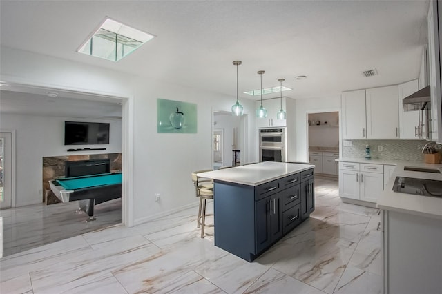 kitchen with marble finish floor, visible vents, stainless steel double oven, white cabinetry, and under cabinet range hood