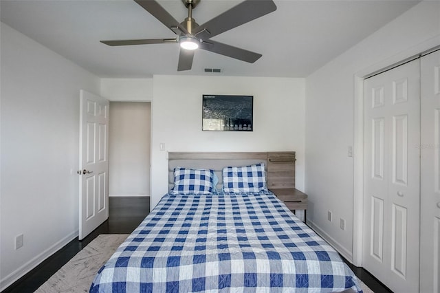 bedroom featuring dark wood-style floors, ceiling fan, visible vents, and baseboards