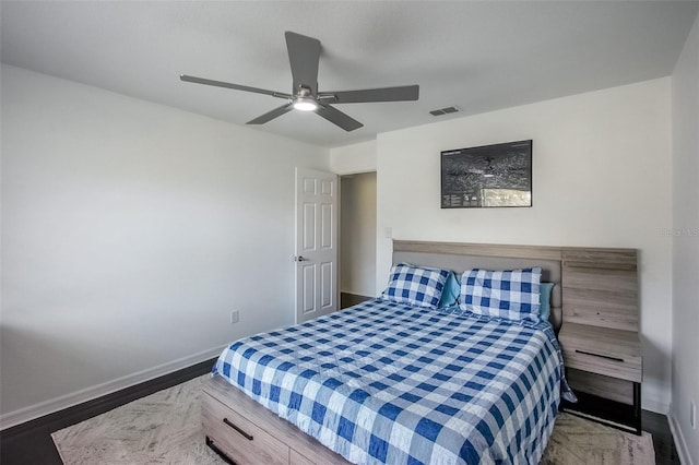 bedroom with visible vents, baseboards, ceiling fan, and wood finished floors