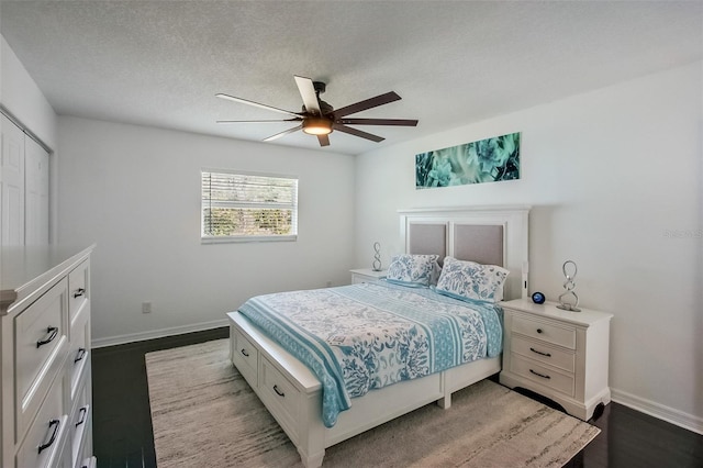 bedroom featuring dark wood-style floors, a closet, baseboards, and a ceiling fan