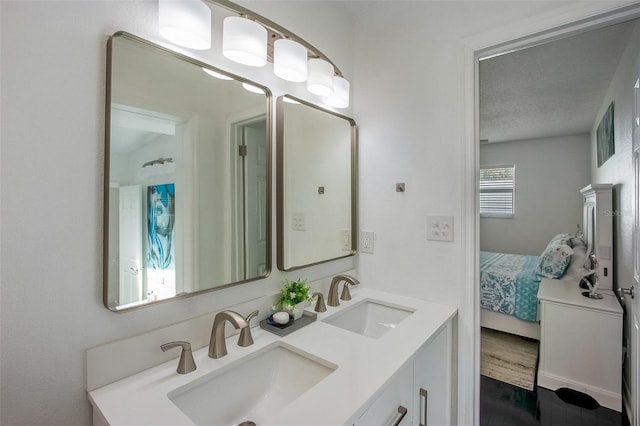 full bathroom featuring double vanity, ensuite bath, a sink, and wood finished floors