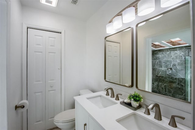 bathroom with a sink, toilet, and a closet