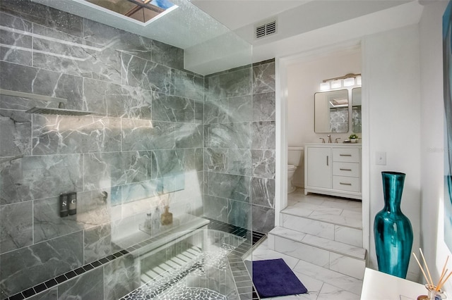 full bath with marble finish floor, visible vents, toilet, vanity, and a walk in shower