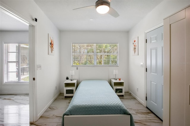 bedroom featuring marble finish floor, multiple windows, and baseboards