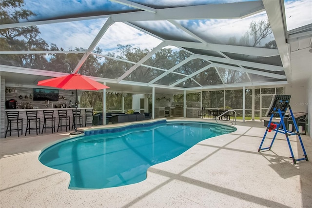 outdoor pool with outdoor dry bar, glass enclosure, and a patio area