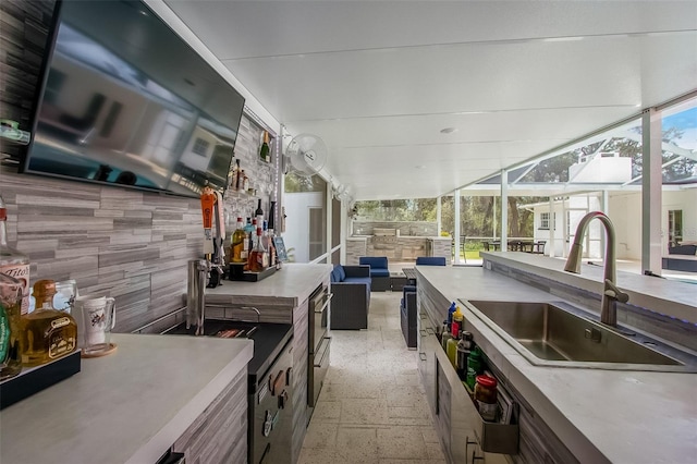 kitchen with open floor plan, a sink, a sunroom, and a healthy amount of sunlight