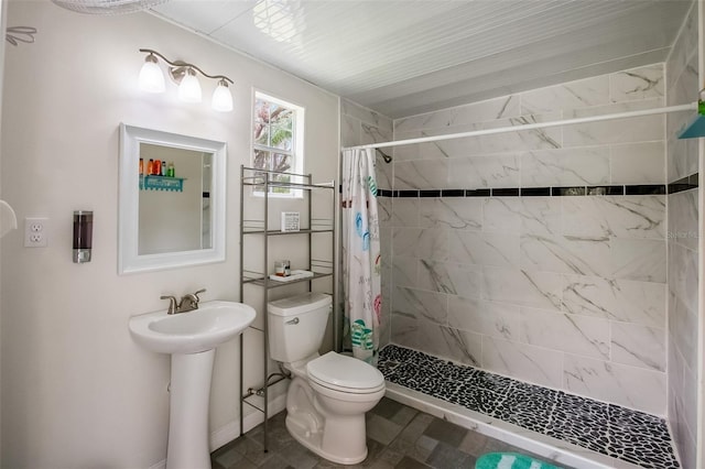 full bathroom featuring a stall shower, a sink, and toilet