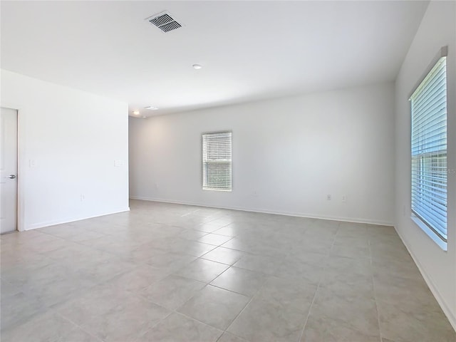 spare room featuring visible vents, baseboards, and light tile patterned floors