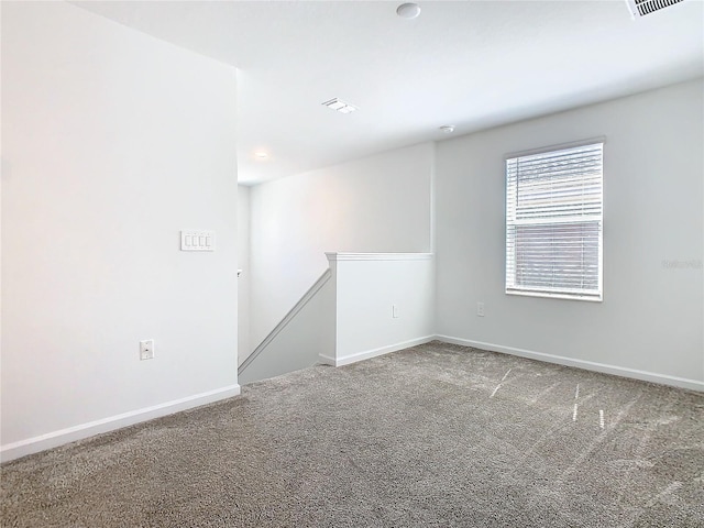 unfurnished room featuring carpet, visible vents, and baseboards