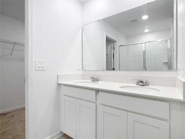 full bathroom featuring a stall shower, visible vents, a sink, and double vanity