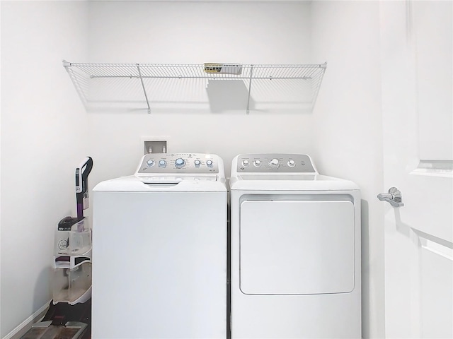 laundry room with laundry area, separate washer and dryer, and baseboards