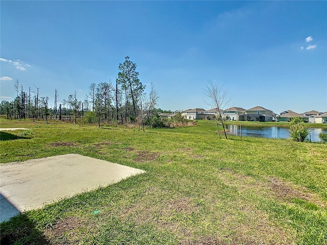 view of yard with a patio area, a water view, and a residential view