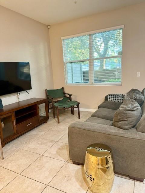 living area with light tile patterned flooring and baseboards