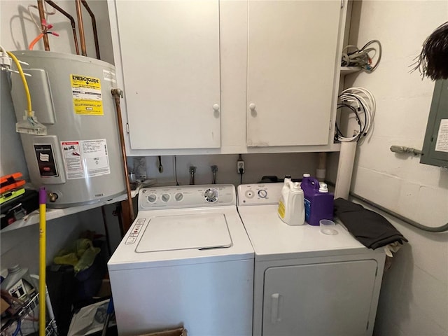 washroom featuring cabinet space, electric water heater, concrete block wall, and washing machine and clothes dryer