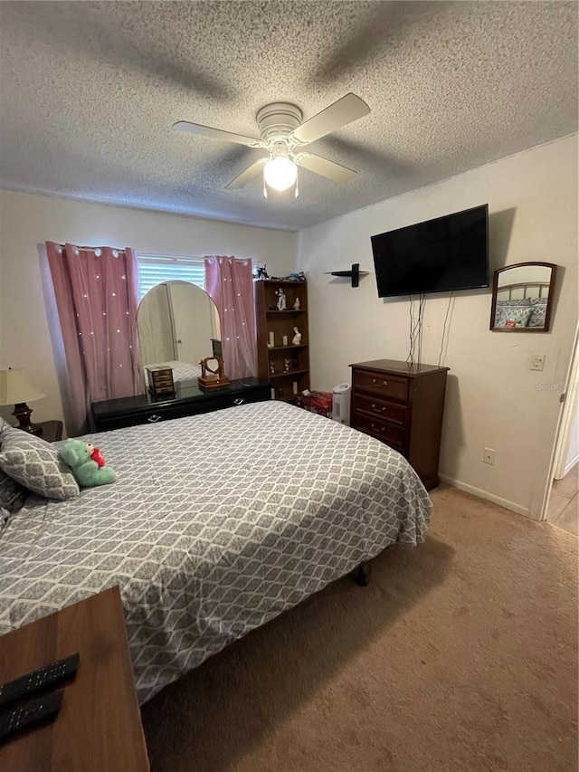 carpeted bedroom featuring a ceiling fan, baseboards, and a textured ceiling