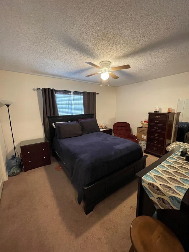 carpeted bedroom with a textured ceiling and a ceiling fan