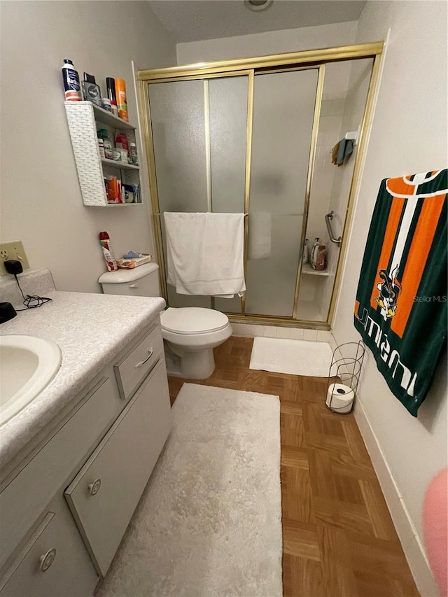 full bathroom featuring baseboards, a shower stall, vanity, and toilet