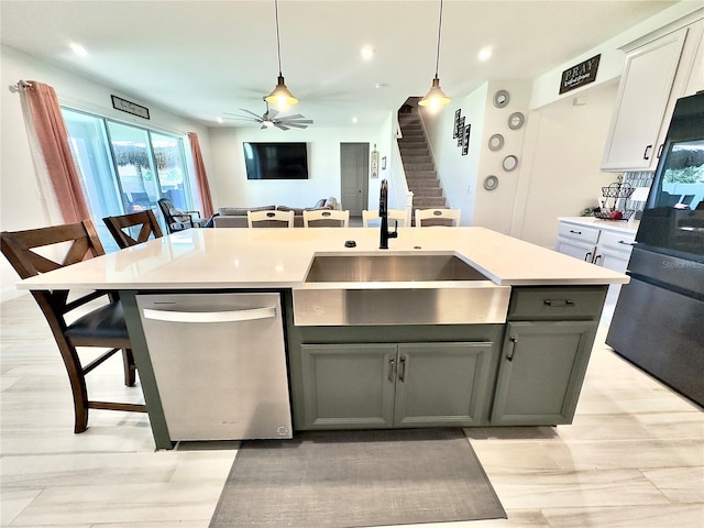 kitchen featuring a sink, decorative light fixtures, freestanding refrigerator, light countertops, and dishwasher