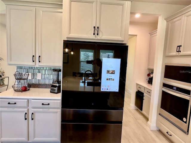 kitchen featuring white cabinetry, appliances with stainless steel finishes, light wood-style flooring, and light countertops