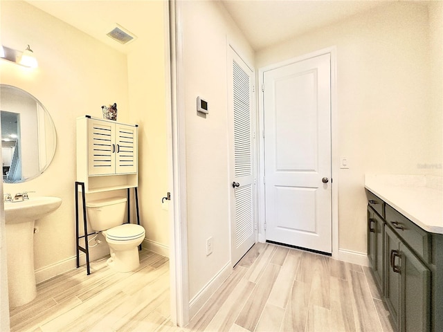 bathroom featuring baseboards, toilet, and wood finished floors