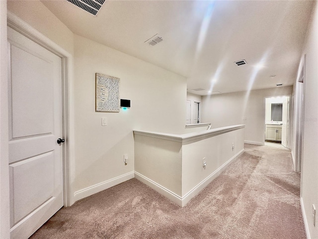 bar featuring baseboards, visible vents, and light carpet