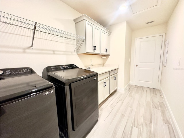 laundry room with light wood-style flooring, washer and dryer, a sink, cabinet space, and baseboards