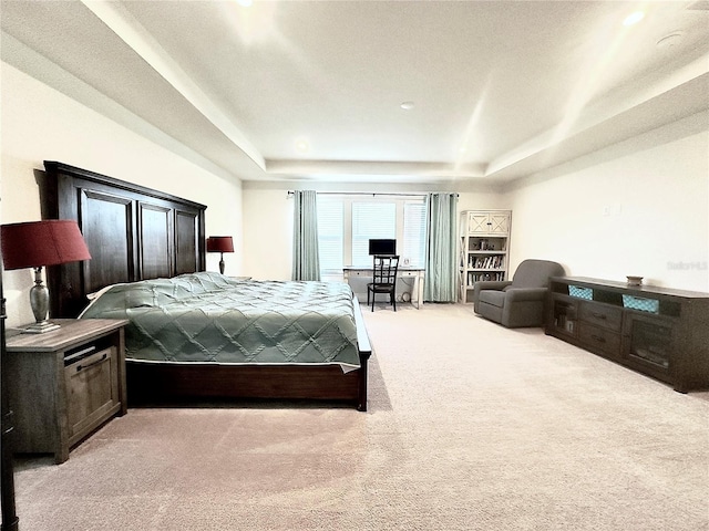 bedroom featuring recessed lighting, light colored carpet, and a tray ceiling