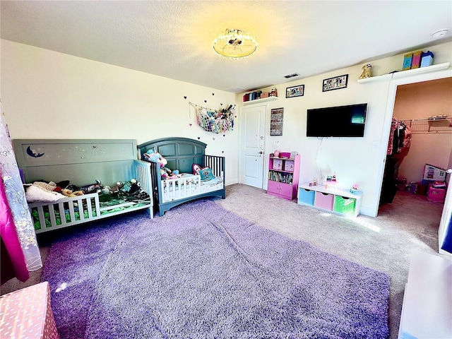 bedroom featuring a spacious closet, visible vents, and carpet floors