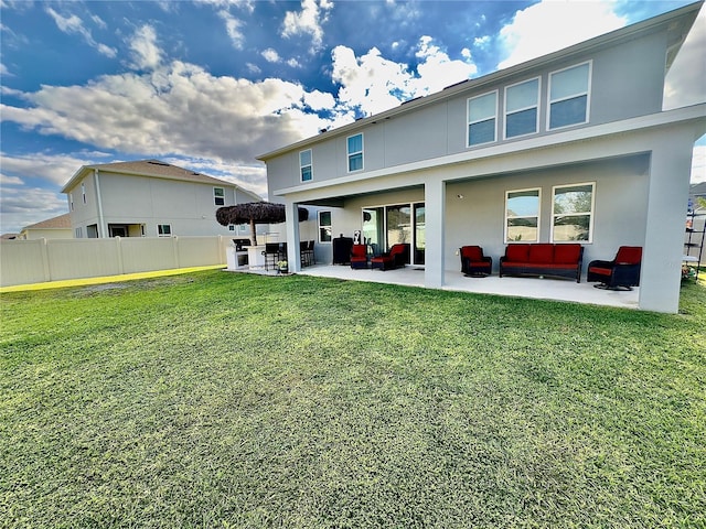 rear view of property with a patio area, a lawn, stucco siding, and fence