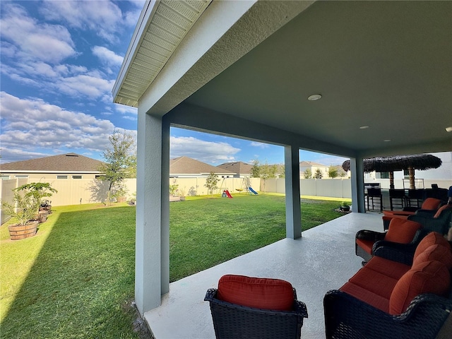 view of patio with a fenced backyard, outdoor lounge area, and a playground