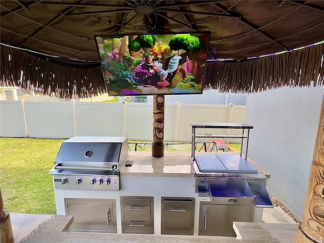 view of patio / terrace with an outdoor kitchen, a grill, and fence