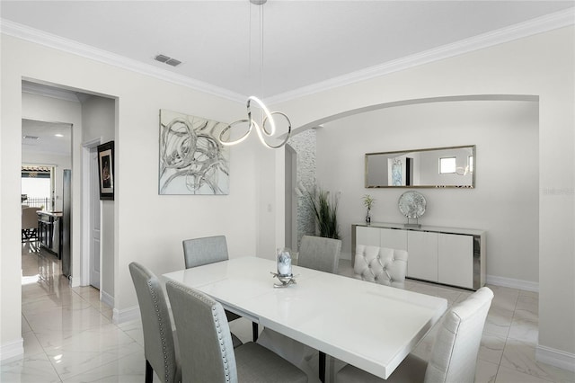 dining room featuring arched walkways, marble finish floor, visible vents, ornamental molding, and baseboards