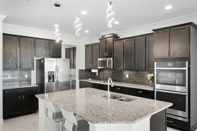 kitchen with marble finish floor, stainless steel appliances, tasteful backsplash, a sink, and light stone countertops