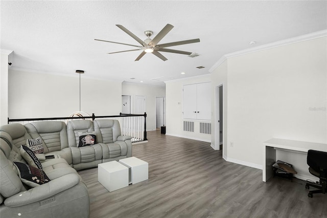 living room with ornamental molding, visible vents, baseboards, and wood finished floors