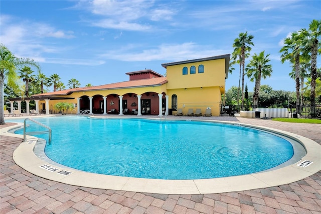 pool with a patio area and fence