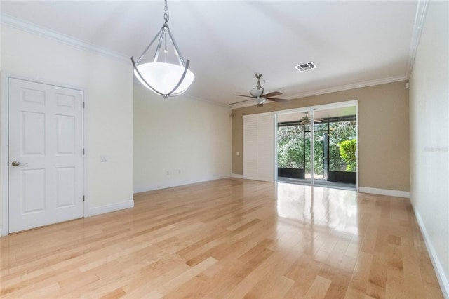 spare room featuring light wood-type flooring, visible vents, crown molding, and ceiling fan