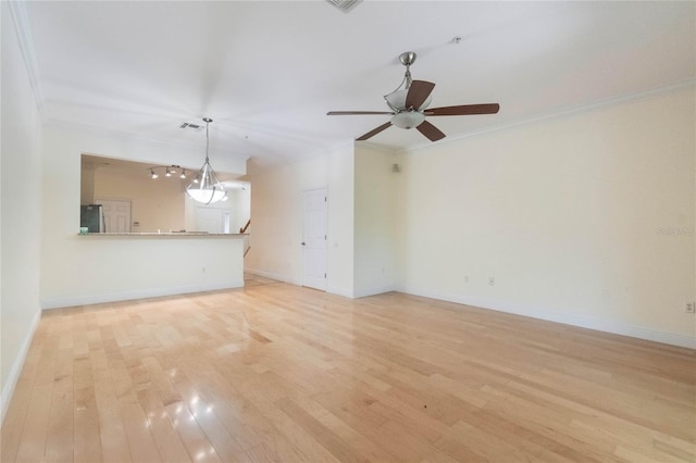 unfurnished living room with ornamental molding, light wood-type flooring, visible vents, and baseboards