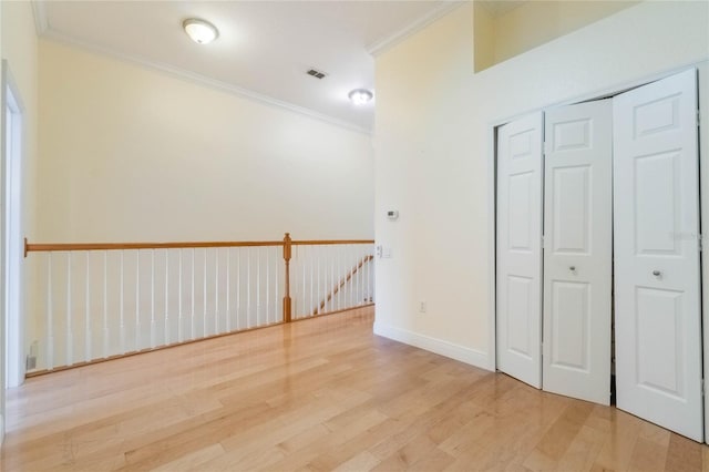 interior space featuring ornamental molding, visible vents, light wood-style floors, and baseboards