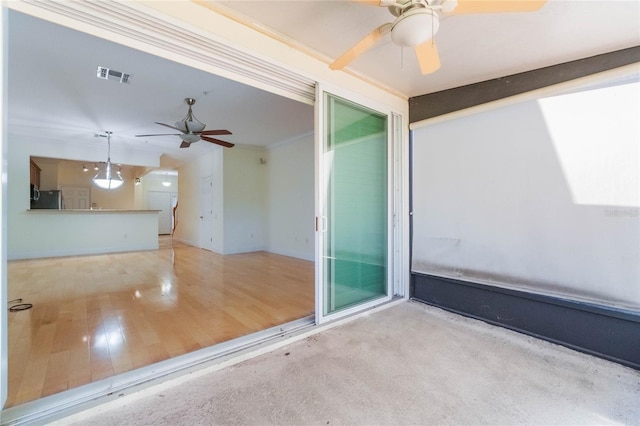 empty room with visible vents, ceiling fan, and wood finished floors