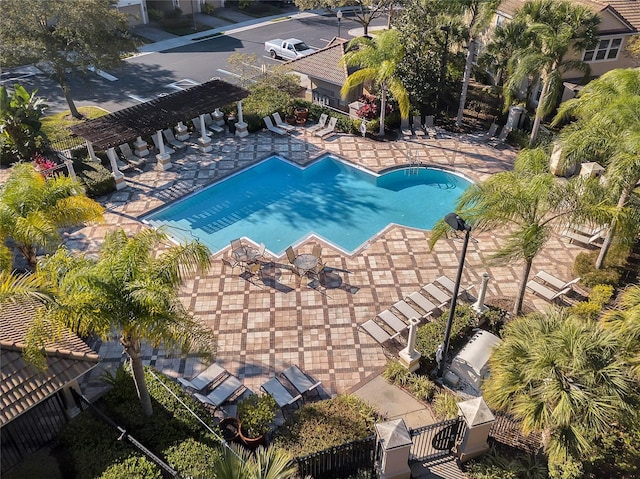 community pool with a patio, fence, and a pergola