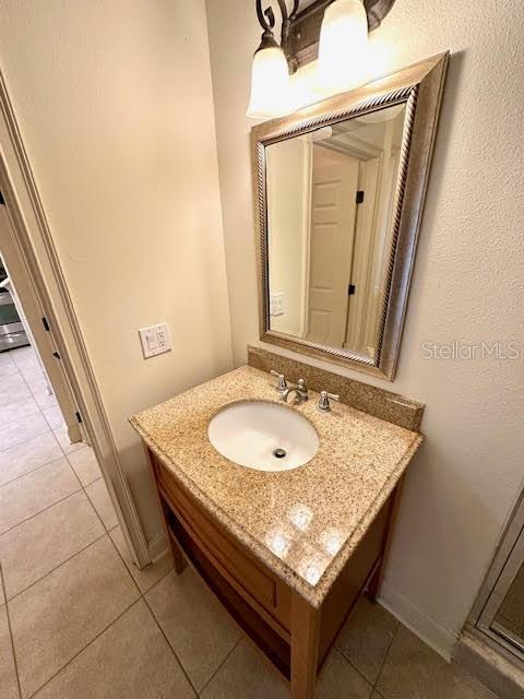 bathroom featuring tile patterned flooring, baseboards, and vanity