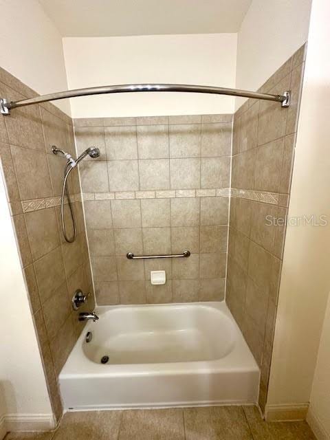 bathroom with baseboards, shower / tub combination, and tile patterned floors