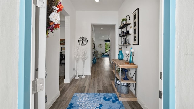 hallway with baseboards, wood finished floors, and recessed lighting