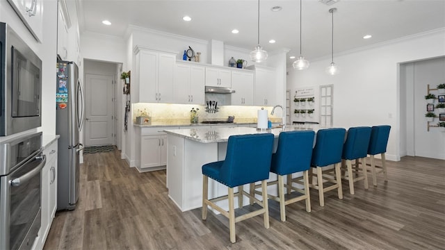 kitchen featuring crown molding, appliances with stainless steel finishes, white cabinets, and under cabinet range hood