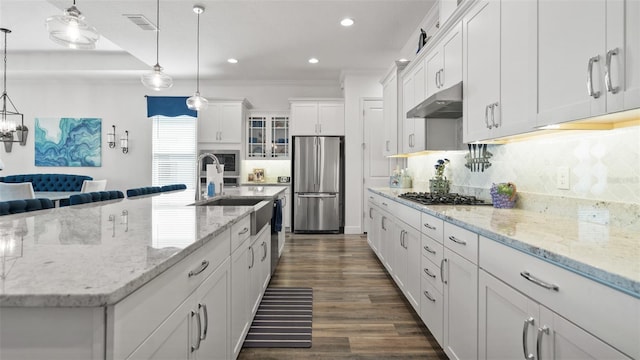 kitchen with visible vents, stainless steel appliances, under cabinet range hood, white cabinetry, and backsplash