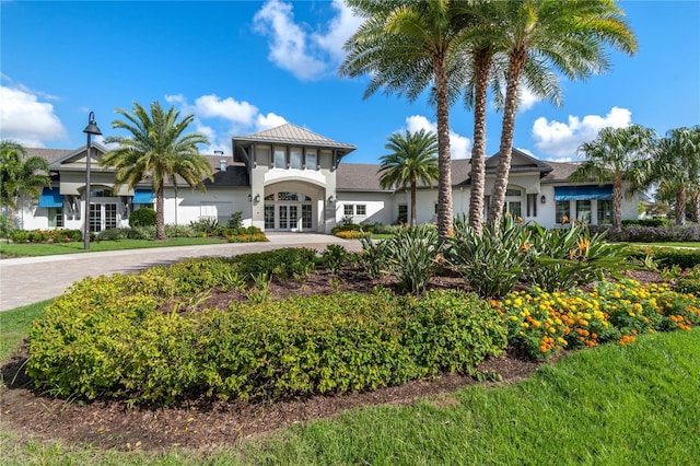 exterior space with french doors, decorative driveway, and stucco siding